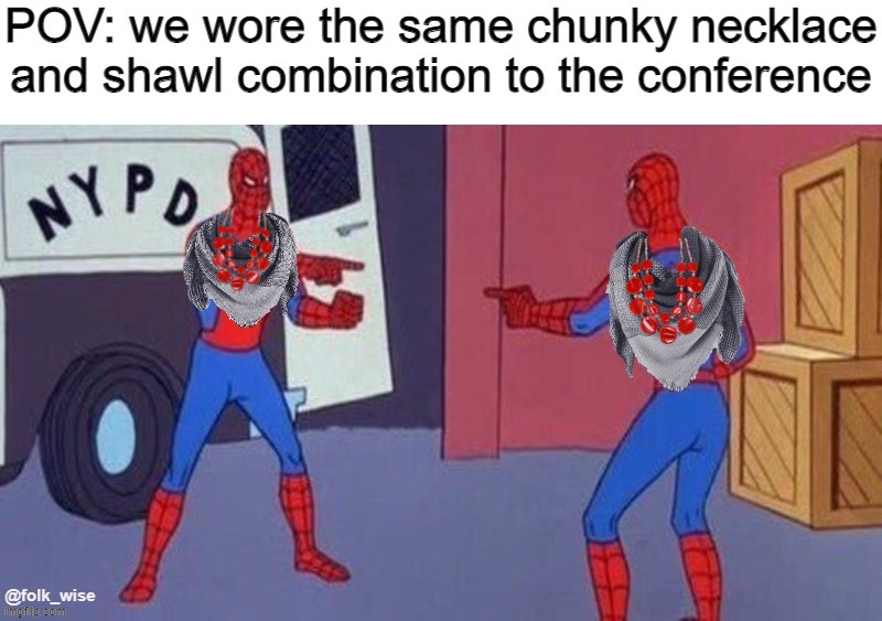 A cartoon image of two people dressed in red and blue SpiderMan superhero costumes (skin-tight suits) pointing at each other in front of a police van outdoors. Both people have a photoshopped gray scarf and large red and gold necklace added to their outfits. Top text reads “POV: we wore the same chunky necklace and shawl combination to the conference.”